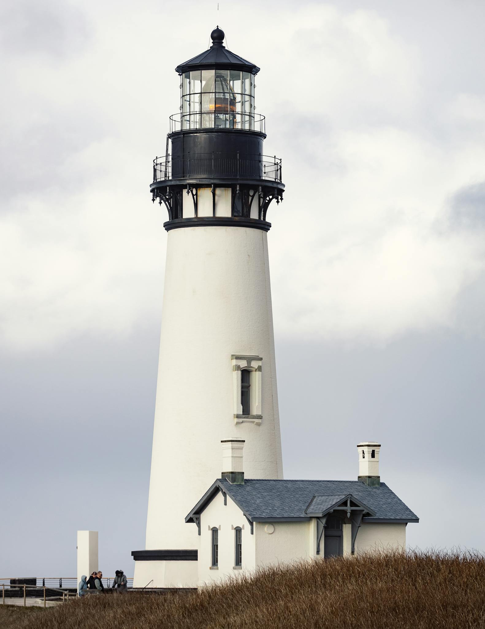 A striking view of Yaquina Head Lighthouse in Newport, Oregon, amidst a cloudy backdrop.